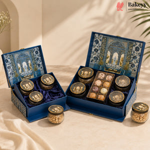 Two ornate blue gift boxes filled with assorted chocolates and nuts, displayed on a draped cream fabric with soft shadows. The boxes feature intricate blue and gold architectural patterns on the inside lids, and the brand name Bakew is visible in the top right corner.