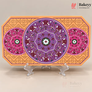 An octagonal decorative tray or board with intricate circular floral mandala patterns in purple, pink, orange, and green, displayed on clear acrylic stands against a light beige background. The Bakeyy brand logo is visible in the top right corner.