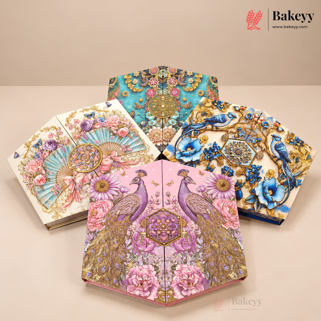Four decorative fan-shaped baked goods or pastries displayed on a beige studio surface, each with intricate floral and bird illustrations. The designs include turquoise, pink, blue, and cream backgrounds with gold detailing, peacocks, flowers, and birds.