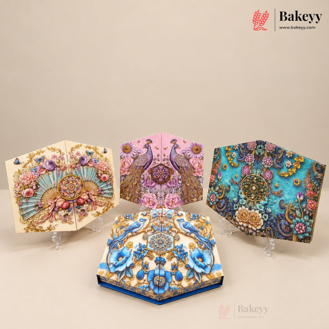 Four decorative 3D box cakes displayed on clear acrylic stands against a warm beige background. The cakes feature intricate 3D floral and peacock designs in vibrant colors including turquoise, pink, cream, and gold.