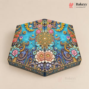 Hexagonal decorative cake box with an intricate floral and paisley pattern in turquoise, gold, pink, and blue, shown on a beige background with the Bakeyy brand logo in the top right.