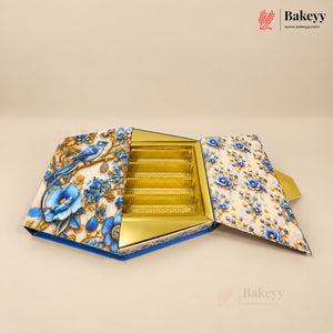 An open hexagonal gift box for pastries or baked goods, featuring a blue and gold floral pattern on the exterior and a gold foil-lined interior with multiple compartments.