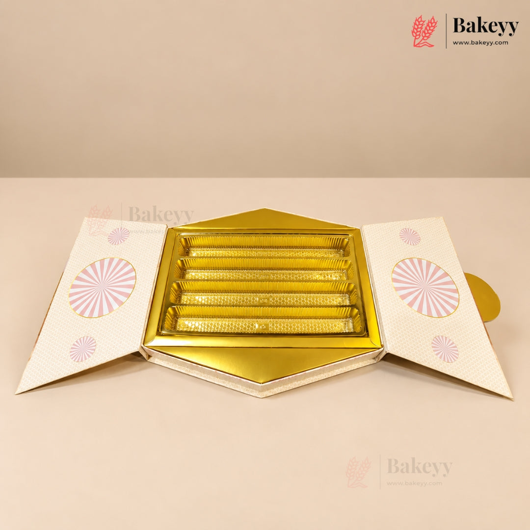 A hexagonal gold and white bakery gift box, shown open to reveal five individual rectangular slots inside. The flaps of the box are white with pink circular sunburst patterns.