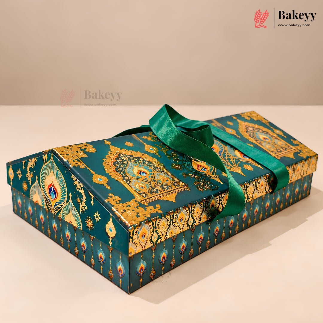 A decorative rectangular gift box with a teal and gold peacock-inspired pattern, tied with a matching teal ribbon, photographed on a light beige surface against a neutral background. The Bakeey brand logo is visible in the top right corner.