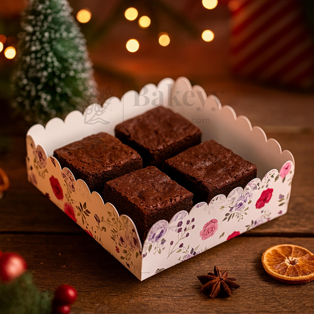 Box of brownies with a decorative lid on a wooden surface with festive decorations.