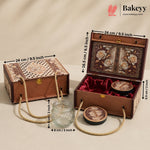 An ornate rectangular gift box set shown closed and open on a beige studio background, with measurement arrows and labels indicating dimensions. The set includes a brown patterned exterior box with rope handles, a matching open box with floral interior panels, red velvet lining, two round decorative containers, and a small clear glass jar.