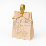 Beige gift box with gold floral design and bow on a white background