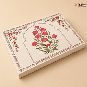A rectangular cream-colored bakery box with traditional Indian floral patterns, featuring a central arch design with red flowers and green leaves, set against a solid beige background.