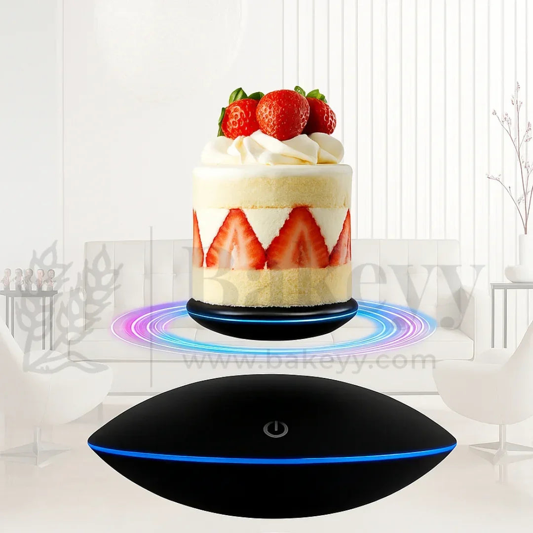 Black levitating device with a cake on a white background