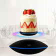 Black levitating device with a cake on a white background