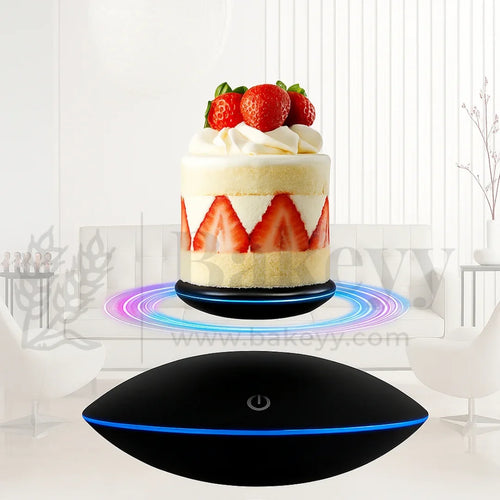 Black levitating device with a cake on a white background