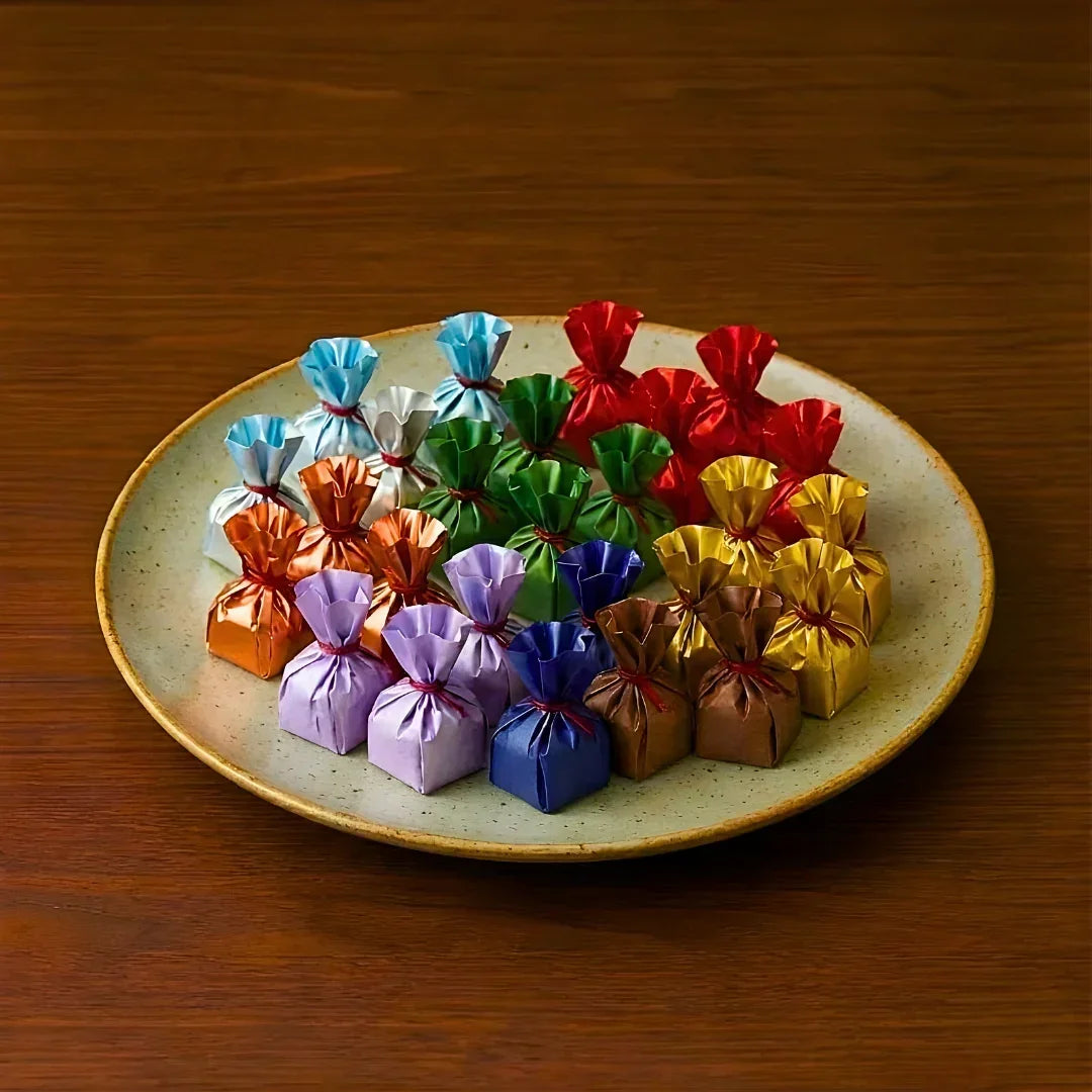 Assorted chocolates in colorful wrappers on a plate, ideal for gift packaging from Bakeyy.com