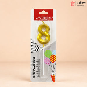 An 8-shaped yellow candle in its retail packaging, featuring a red and white header that reads 'HAPPY BIRTHDAY' and decorative graphics on a beige background.