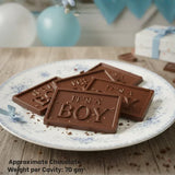 Bakeyy chocolate bars with 'It's a Boy' text on a plate, perfect for baby shower gifts.