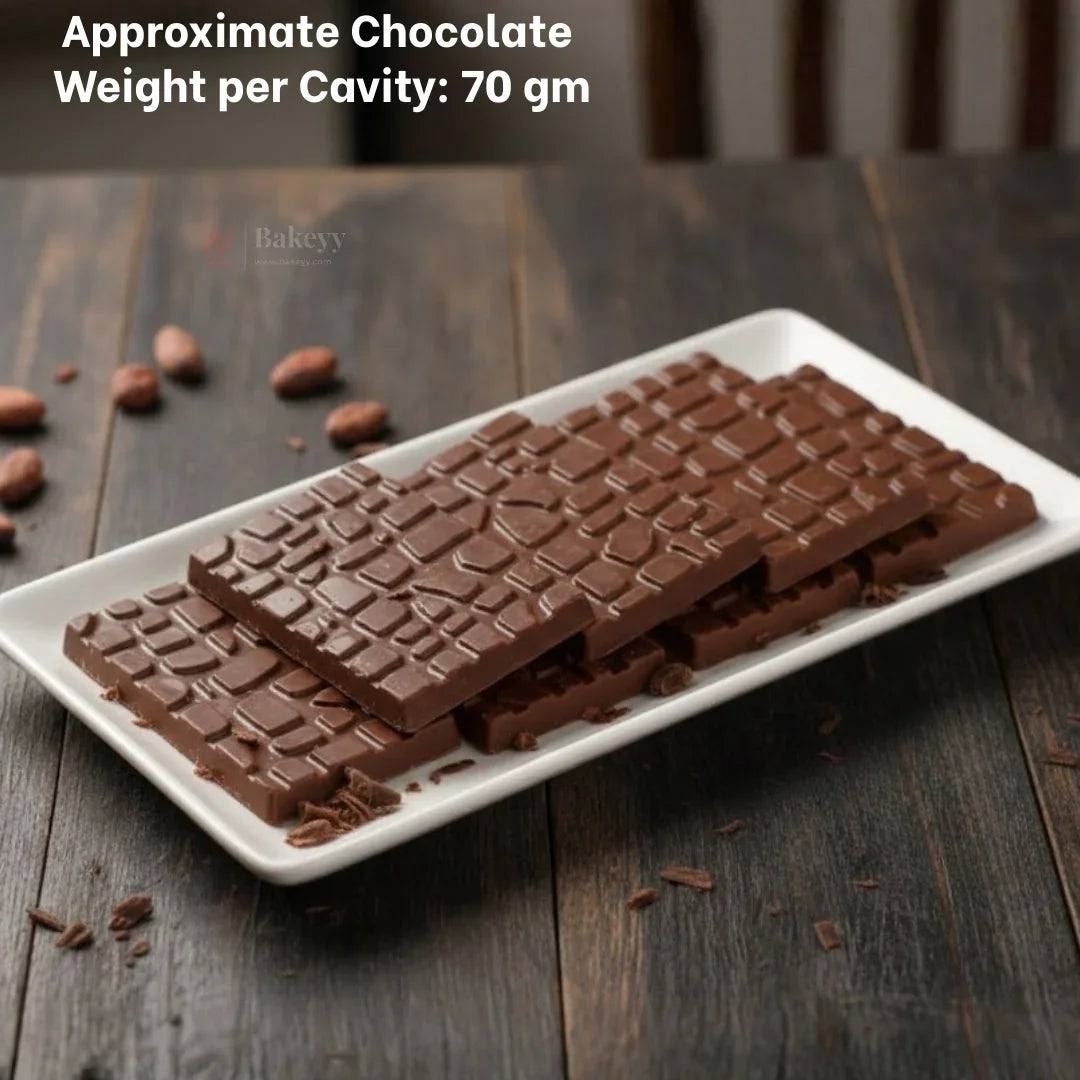 Cracked stone chocolate bars made with Bakeyy plastic mould on a white tray, wood background