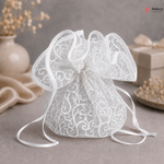 White lace gift bag on a gray surface with decorative elements in the background