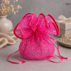 Pink lace drawstring bag with a red ribbon on a gray surface