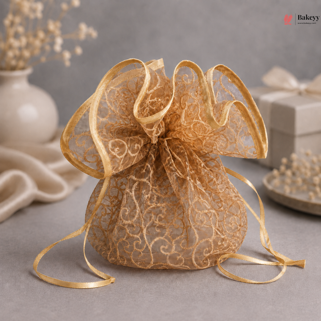 Gold lace bag with decorative ribbon on a gray surface