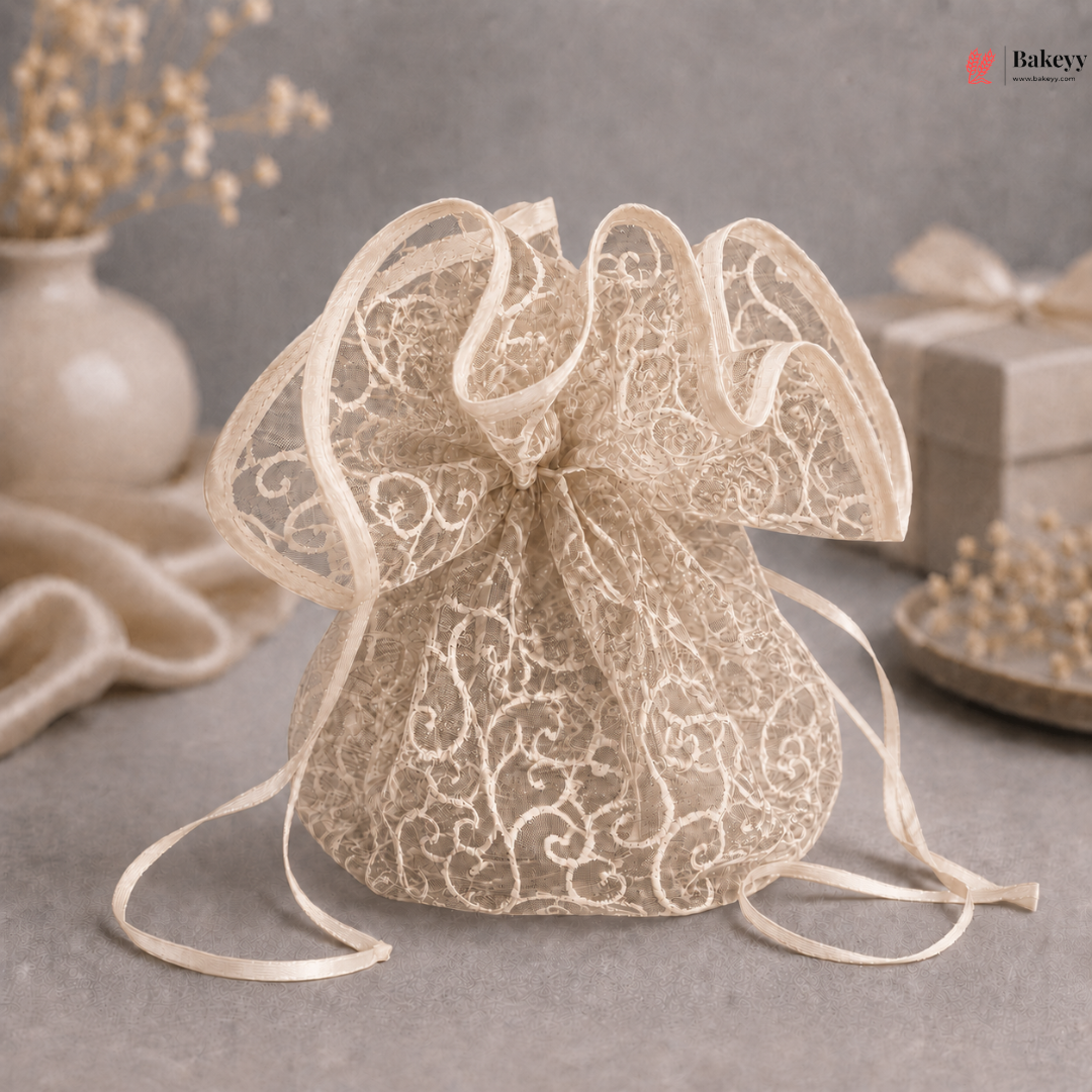 Beige lace drawstring bag on a gray surface with decorative elements in the background.