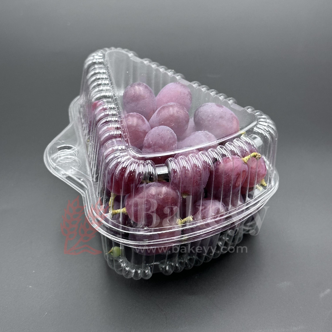 Clear plastic container with red grapes on a gray background