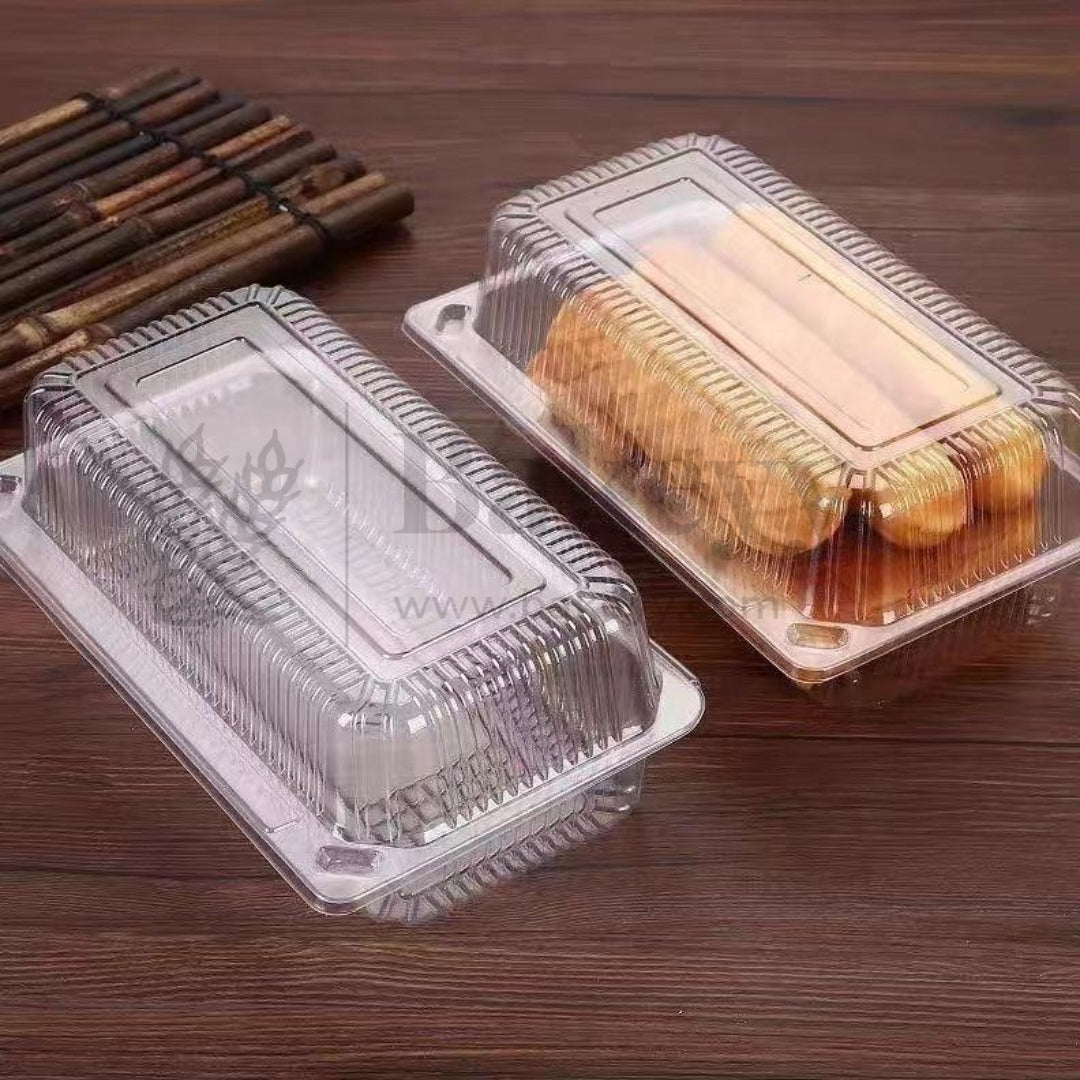 Clear plastic food containers with baked goods on a wooden surface