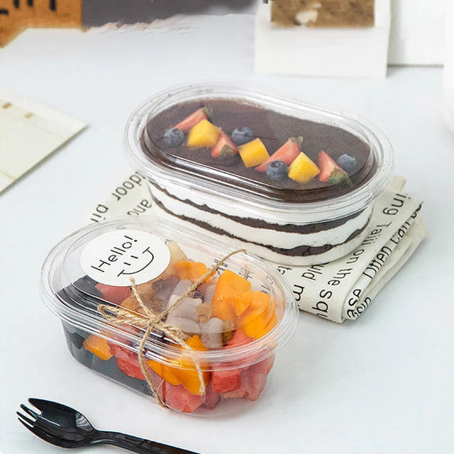 Two dessert containers with fruit on a white surface