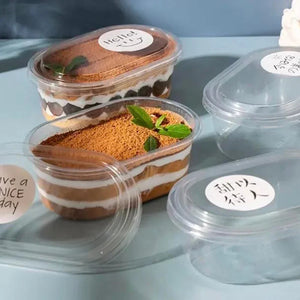 Three layered dessert in clear containers with lids on a light blue surface