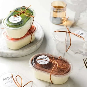 Three small containers of dessert with labels on a marble surface