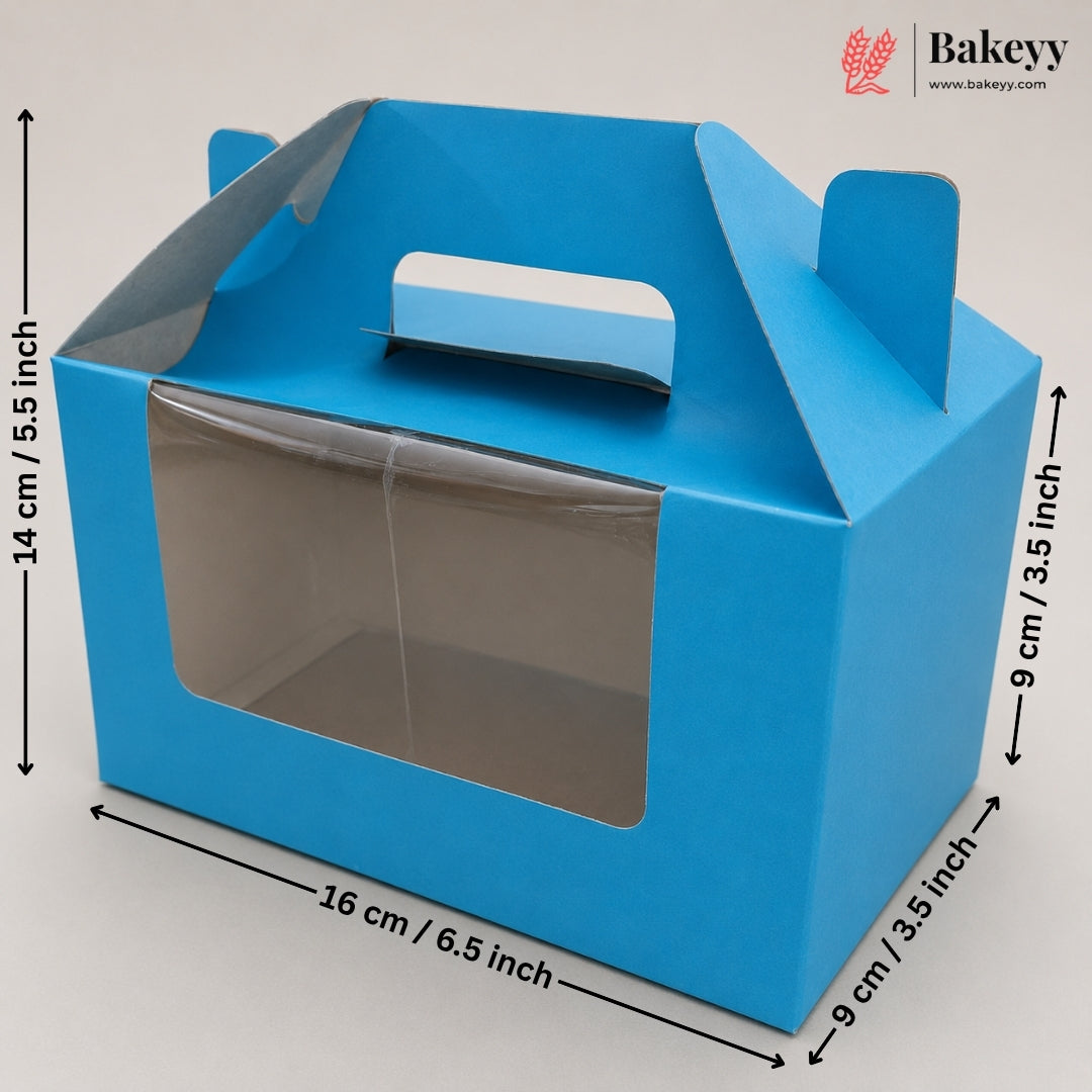 Blue bakery gift box with a clear front window and top handle, shown with dimension arrows and labels indicating 14 cm height, 16 cm width, and 9 cm depth on a light gray background. Bakeyy logo appears in the top right.