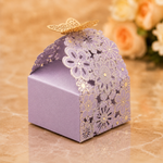 Decorative purple gift box with gold floral patterns and a butterfly on a marble surface.
