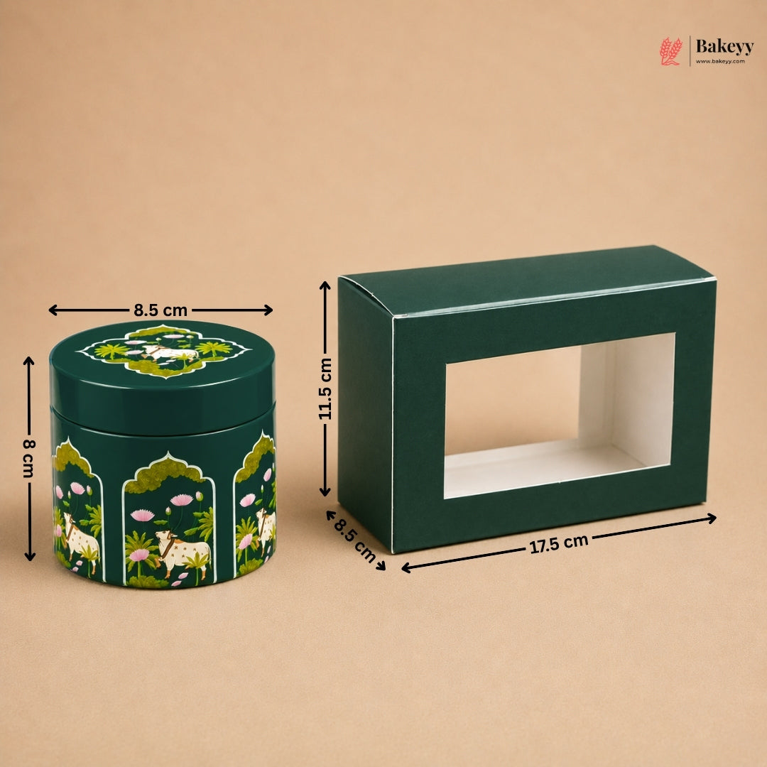 A dark green rectangular display box with a front window and a matching round decorative tin with animal and floral illustrations, shown on a beige background with dimension arrows and labels.