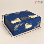 A rectangular blue decorative box with gold and cream cow motifs and floral patterns, shown on a light beige background with dimension arrows and text indicating 30.9 cm length, 28.