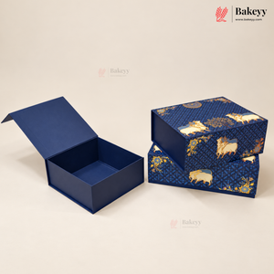 A navy blue bakery gift box with gold foil patterns, shown with one open box displaying its interior and two stacked boxes on a light beige background. The Bakeyy logo is visible in the top right corner.