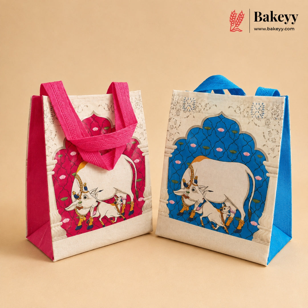 Two decorative reusable gift bags with fabric handles, shown on a warm beige background. The left bag has a pink arched panel with a white cow illustration and pink handles.