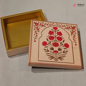 A decorative rectangular bakery gift box with a gold interior and a cream-colored exterior featuring a red floral arch design, shown with the lid placed beside the open base on a light gray surface.