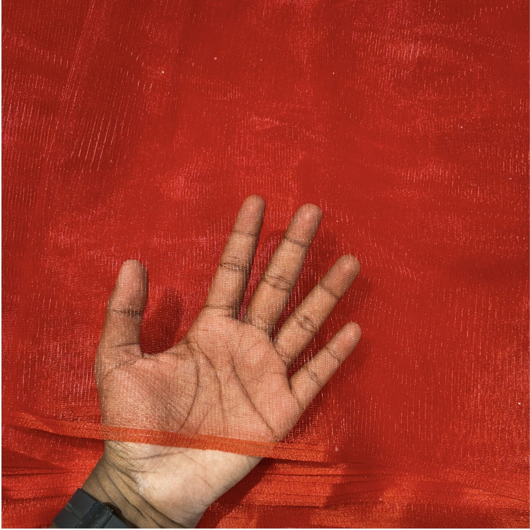 A hand laid flat against a bright red sheer mesh fabric background, showing the texture and transparency of the material.