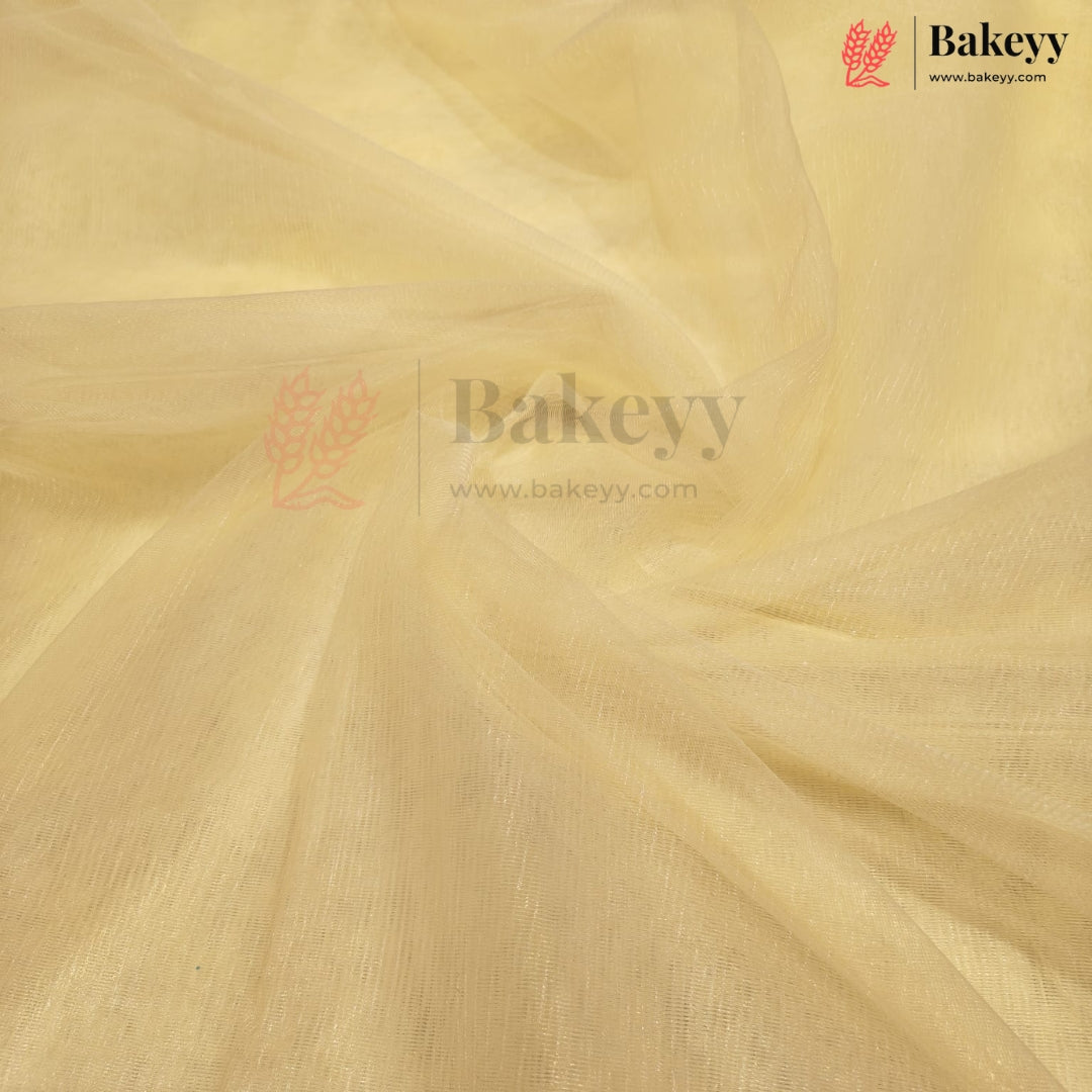 A close-up of draped pale yellow fabric with a soft, semi-sheer texture and visible weave, featuring a Bakeyy watermark logo in the center and top right corner.