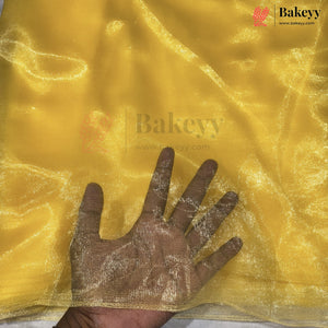 Yellow sheer mesh fabric with a hand placed underneath to show transparency, from Bakeyy.