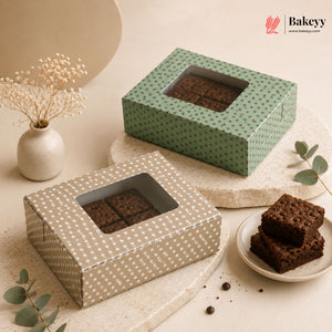 Two brownie boxes with a window on a light surface, with 'Bakeyy' branding.