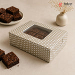 Polka dot brownie box with brownies on a beige surface, featuring the Bakey brand.