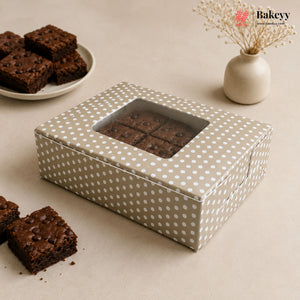 Polka dot brownie box with brownies on a beige surface, featuring the Bakey brand.