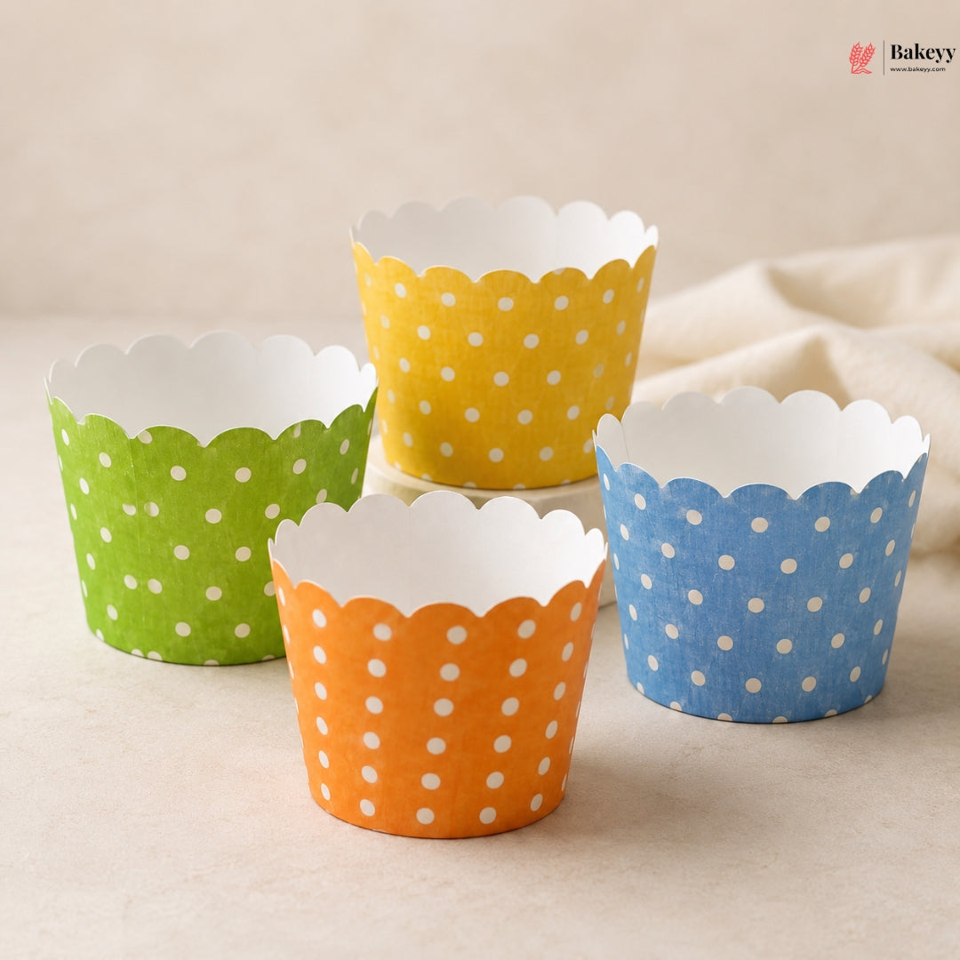 Four colorful polka dot cupcake liners on a beige surface with 'Bakery' branding.