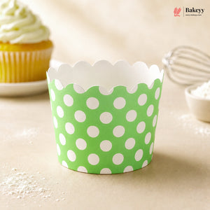 Green cupcake liner with white polka dots on a beige surface, with 'Bakey' branding.