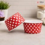 Red polka dot baking cups on a light surface with a blurred background