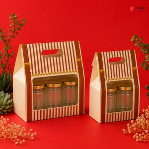 Two cardboard gift boxes with glass jars on a red background