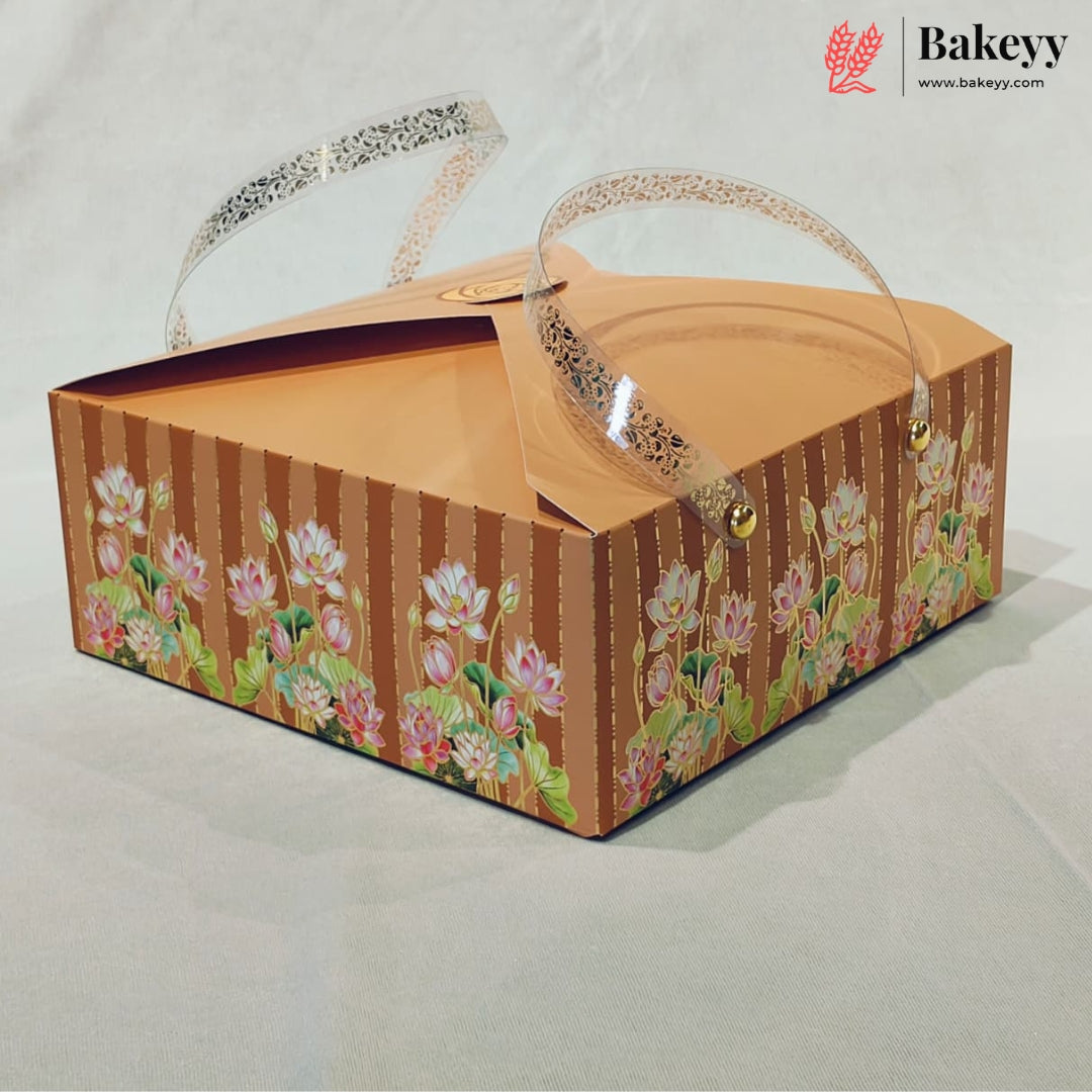 A square cardboard bakery box with a brown striped and floral patterned exterior, clear plastic handles, and a Bakeyy logo watermark in the top right corner.