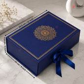 A royal blue rectangular gift box with a gold mandala design on the lid, tied with a matching blue ribbon, shown on a marble surface with dimension arrows and labels indicating 30.5 cm by 20 cm by 10 cm.