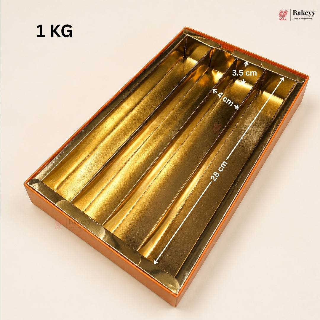 Gold metallic 4-compartment gift box with white dimension arrows and text overlays showing measurements (28 cm, 4 cm, 3.5 cm) and a '1 KG' weight label on a light beige background.