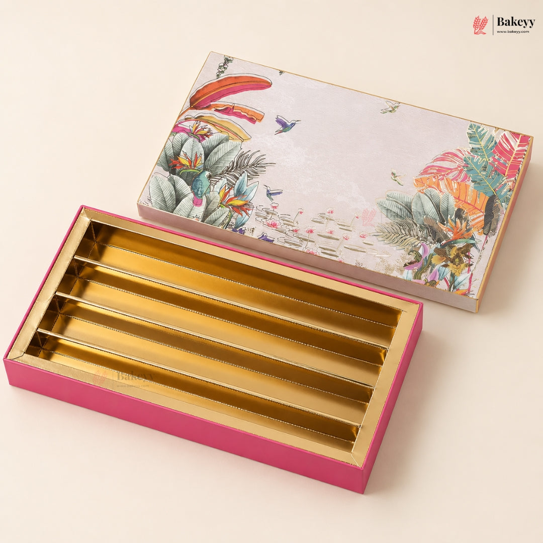 A rectangular bakery gift box set shown on a warm cream background. The lower box is open, revealing five gold-lined slots inside a bright pink outer shell.