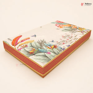 A rectangular decorative cake or gift box with a tropical bird and floral print on the lid and a red patterned side border, shown on a plain light beige background. A Bakeey logo appears in the top right corner.
